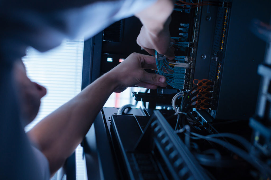 Hard working experienced technician working with network cables network services with Bizz office Solutions